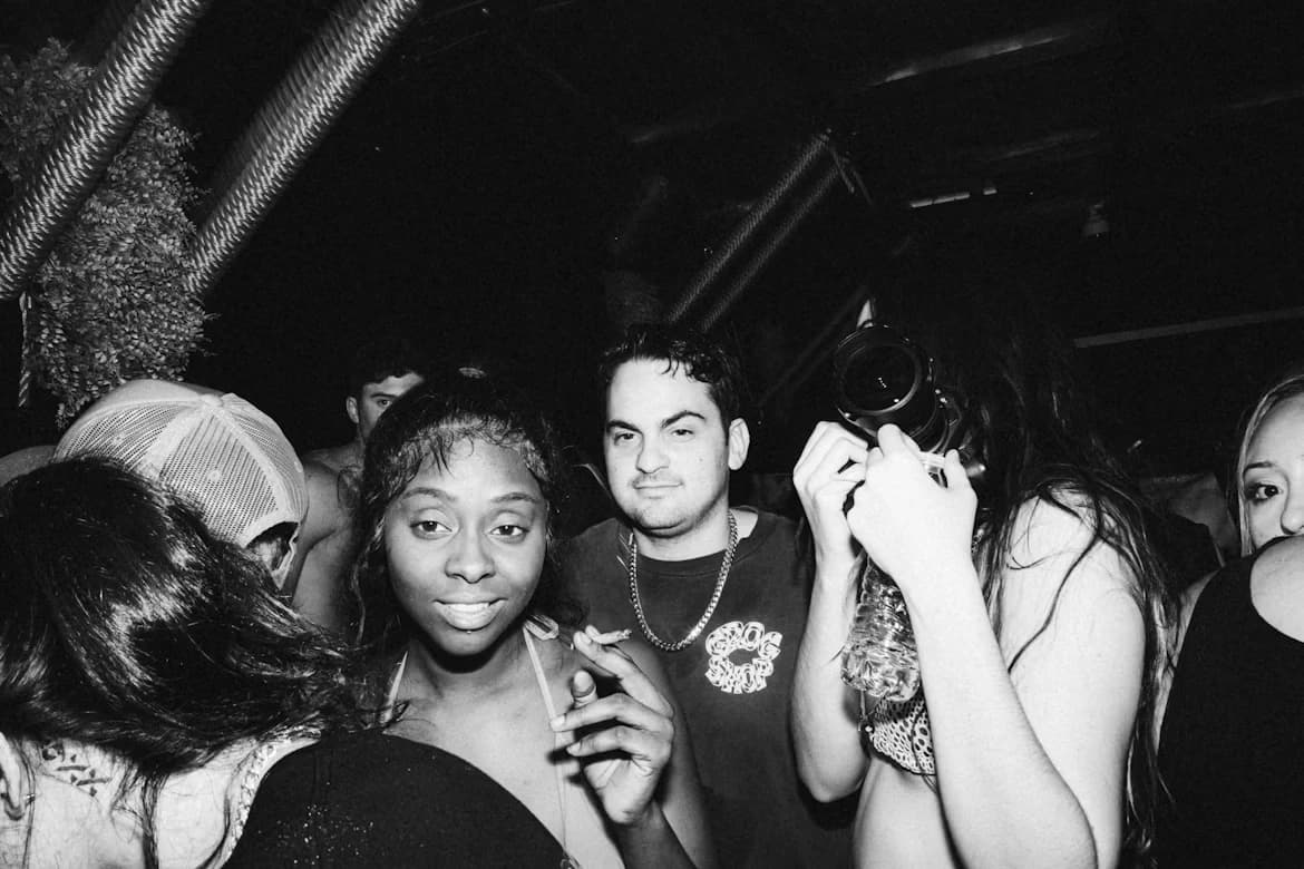 A crowd close together at a party, shot in black and white