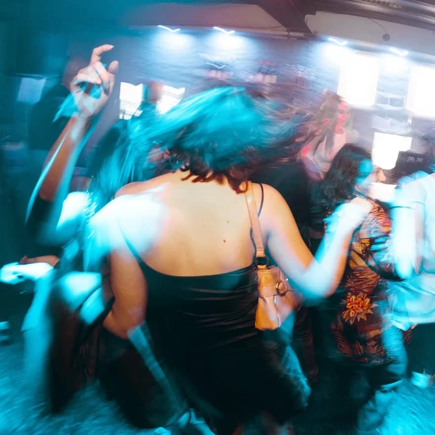 A club floor under blue light, caught mid-movement
